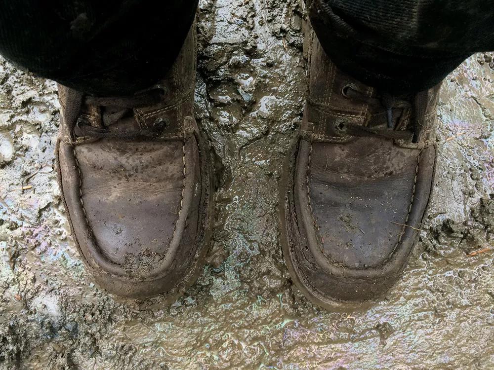 Las botas caladas sobre el suelo fangoso.